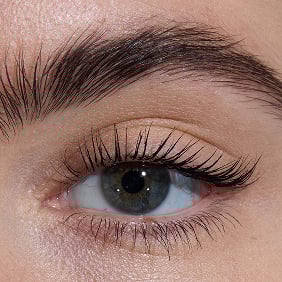 Close-up of an eye with light skin tone, showcasing lengthened lashes from YSL Lash Latex Mascara with level two intensity.