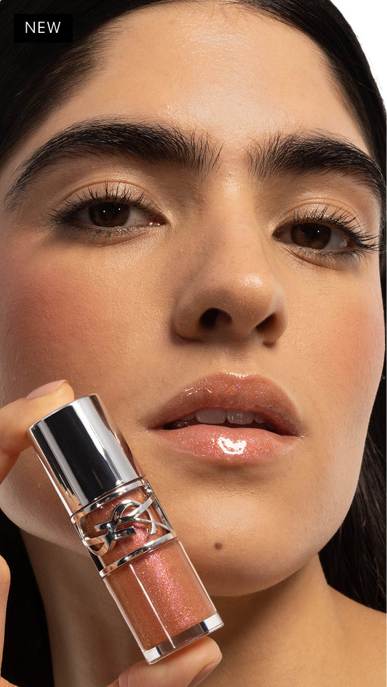 Natalia's gaze captivates, lips adorned with YSL LOVESHINE Plumping Lip Oil Gloss 12 Stardust, product held close.